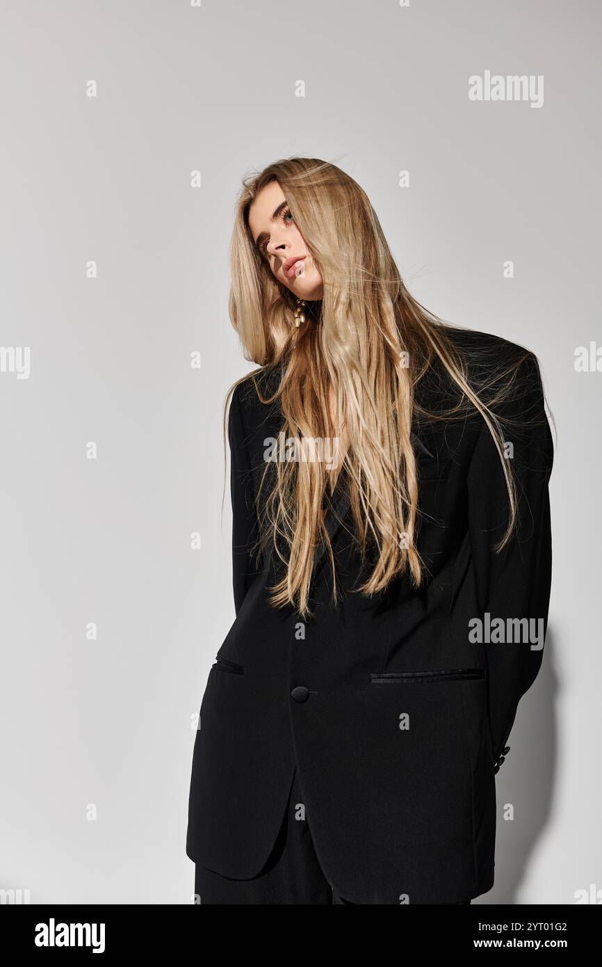 A beautiful young woman with long blonde hair poses confidently in a ...
