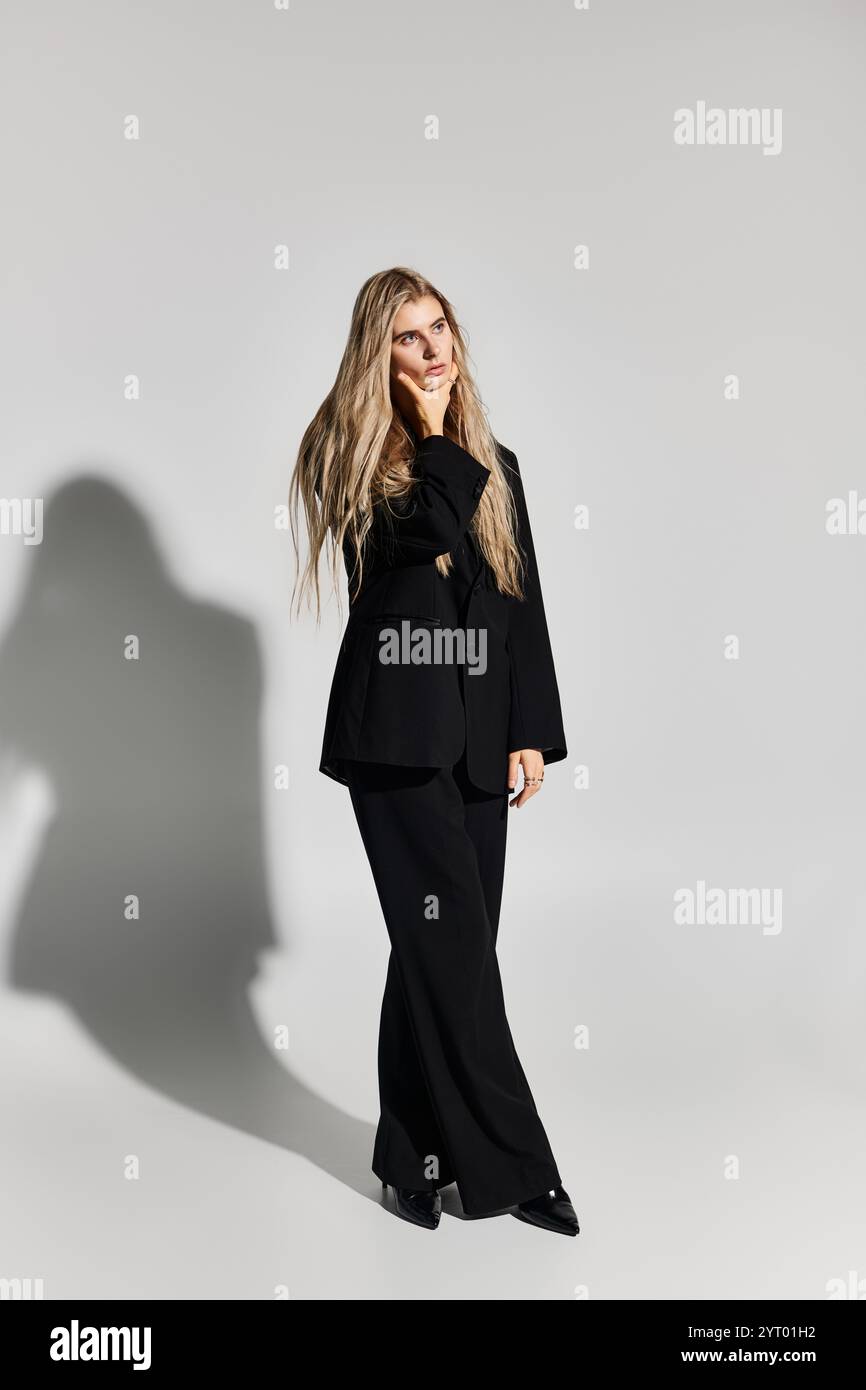 A beautiful young woman with long blonde hair poses confidently in a ...
