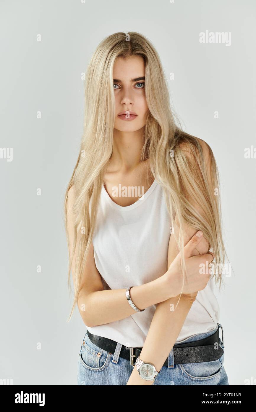 A beautiful young woman with long blonde hair poses elegantly in a ...