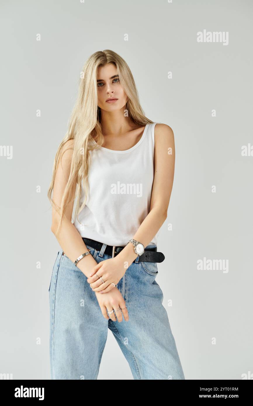 A stunning young woman with long blonde hair poses casually ...