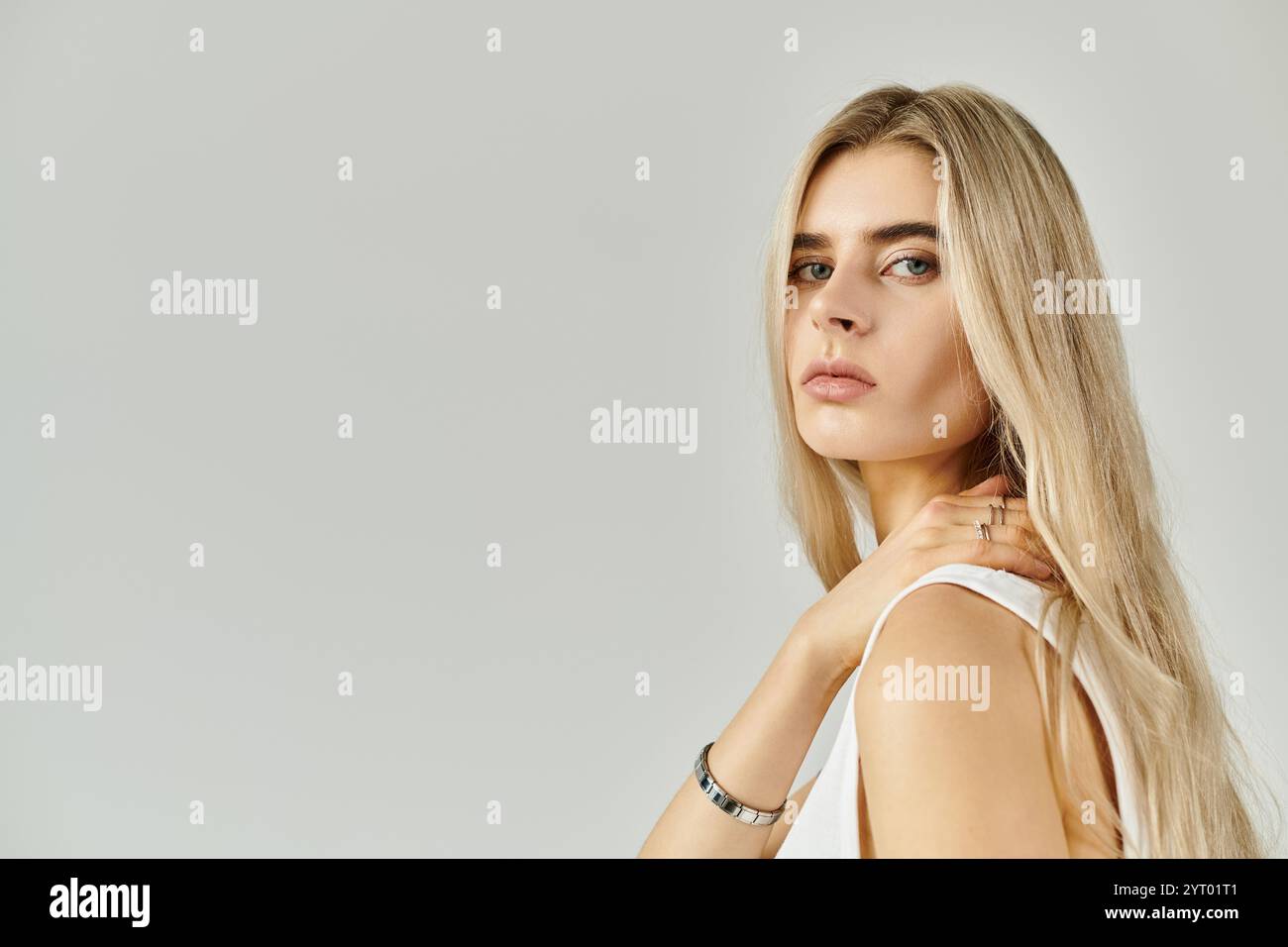 A beautiful young woman with long blonde hair elegantly poses in a ...