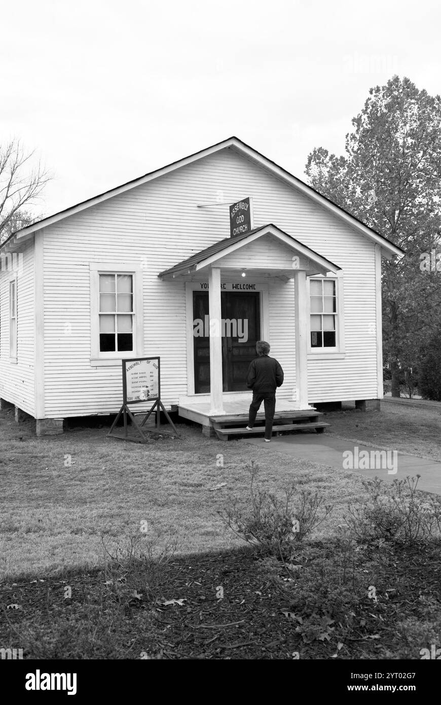 Caucasian senior woman walking up the steps of the Assembly of God Church at the Elvis Presley Birthplace Museum and Chapel in Tupelo, Mississippi. Stock Photo