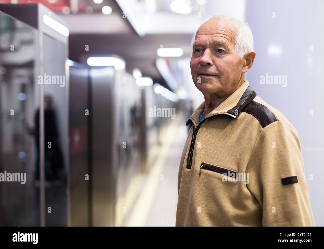 Elderly man getting on modern subway car. Concept of daily city trips Stock Photo