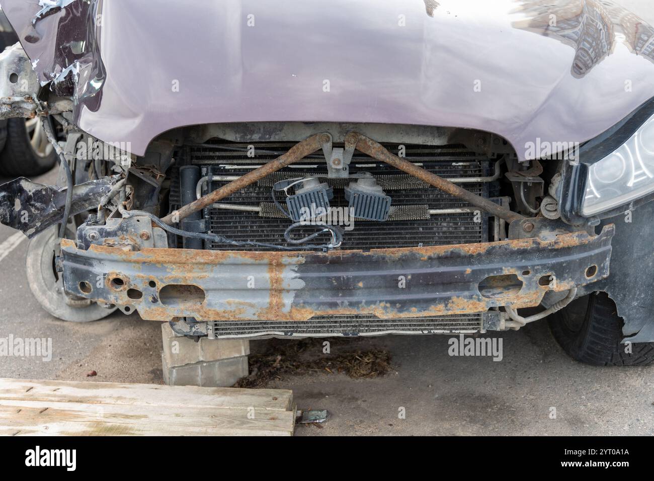 A passenger car is parked in the parking lot with damage to the right front part as a result of an accident. The suspension, fender, hood and radiator Stock Photo