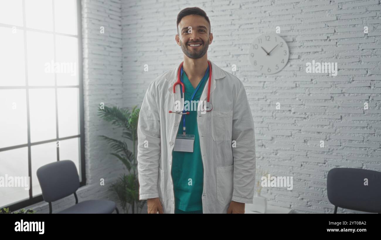 A handsome young hispanic male doctor with a beard stands smiling in a ...