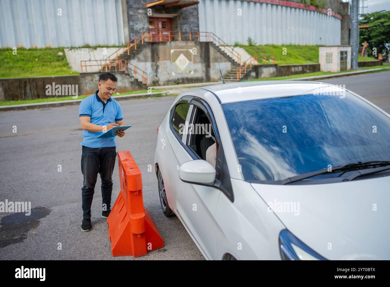 A traffic officer is assisting a driver at a roadside checkpoint that ...