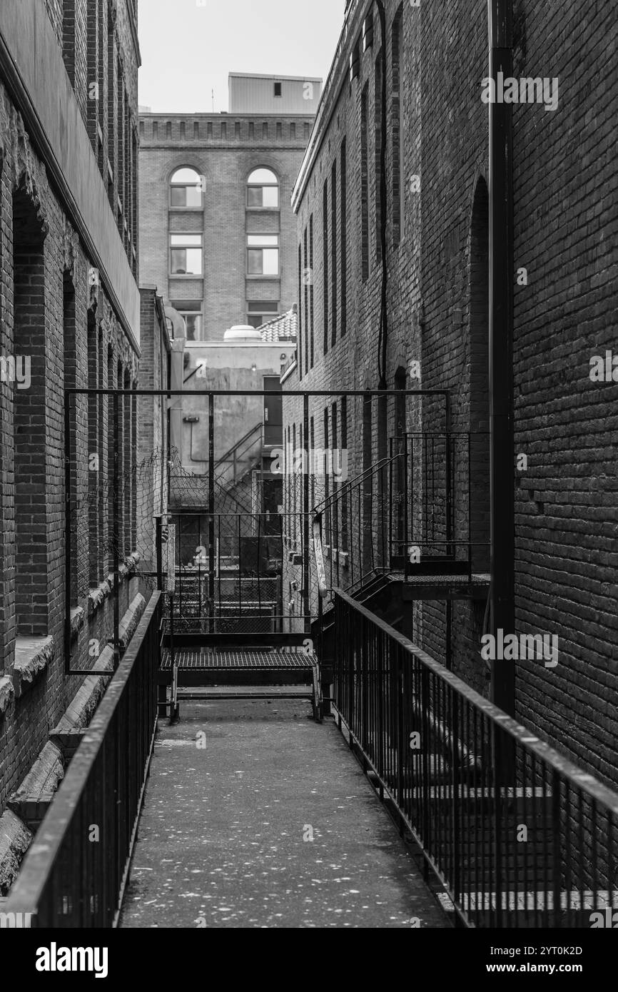 Narrow alleyway between two brick houses at an urban location. The ...