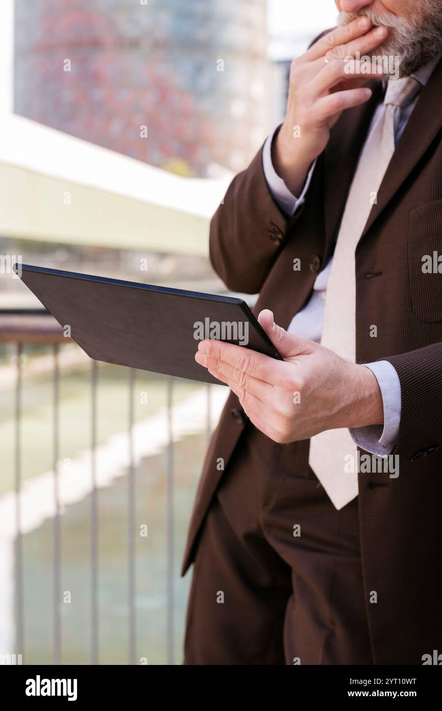close up of unrecognizable man browsing tablet Stock Photo