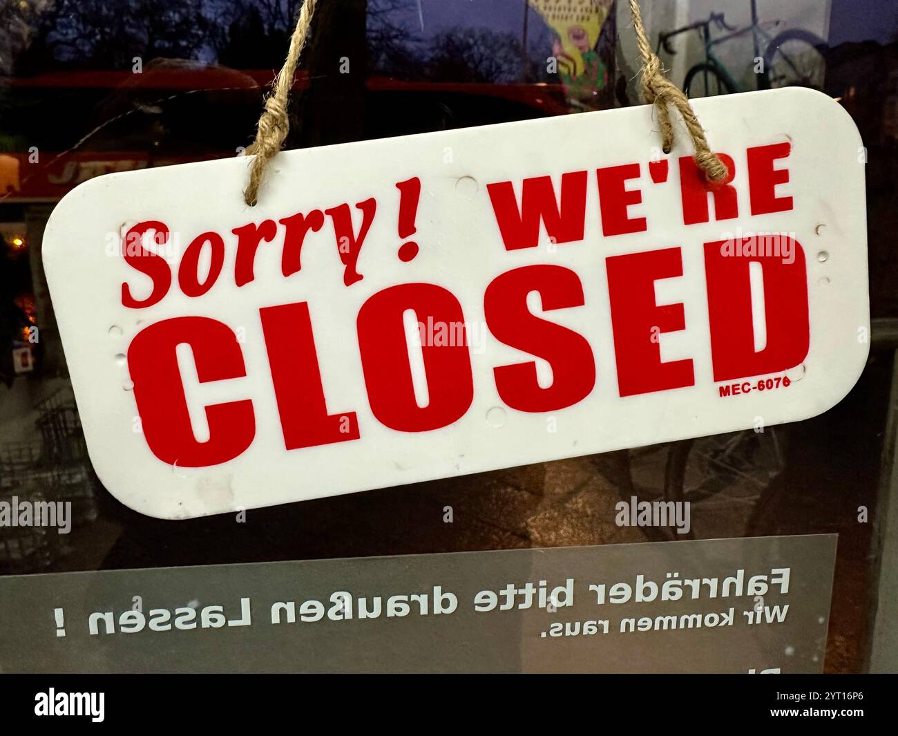 A sign saying 'Sorry! We're closed' viewed from the inside of a shop - Smartphone Captured Stock Image