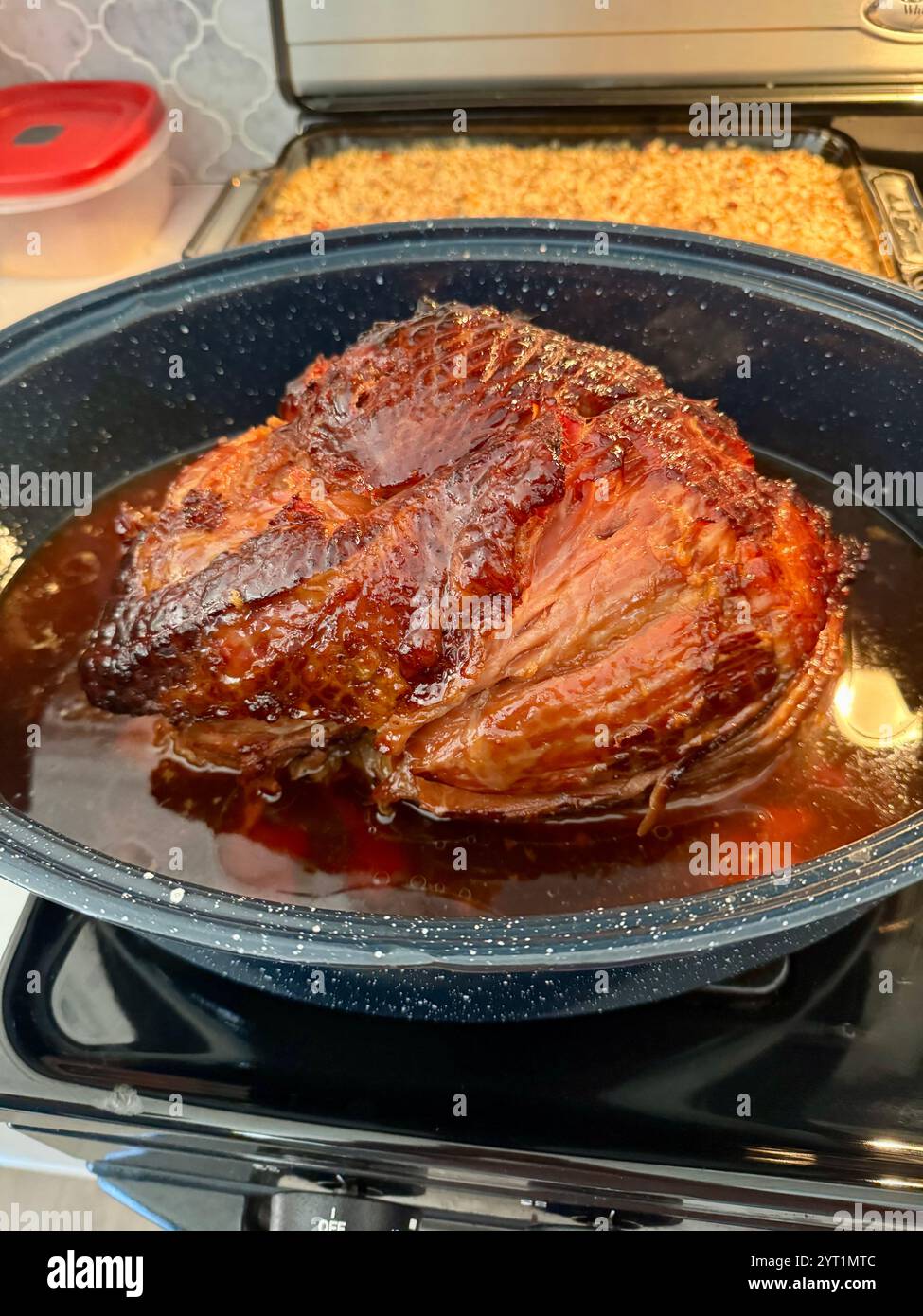 Holiday ham just out of the oven in roaster with glaze juices to be sliced for serving. USA - Smartphone Captured Stock Image