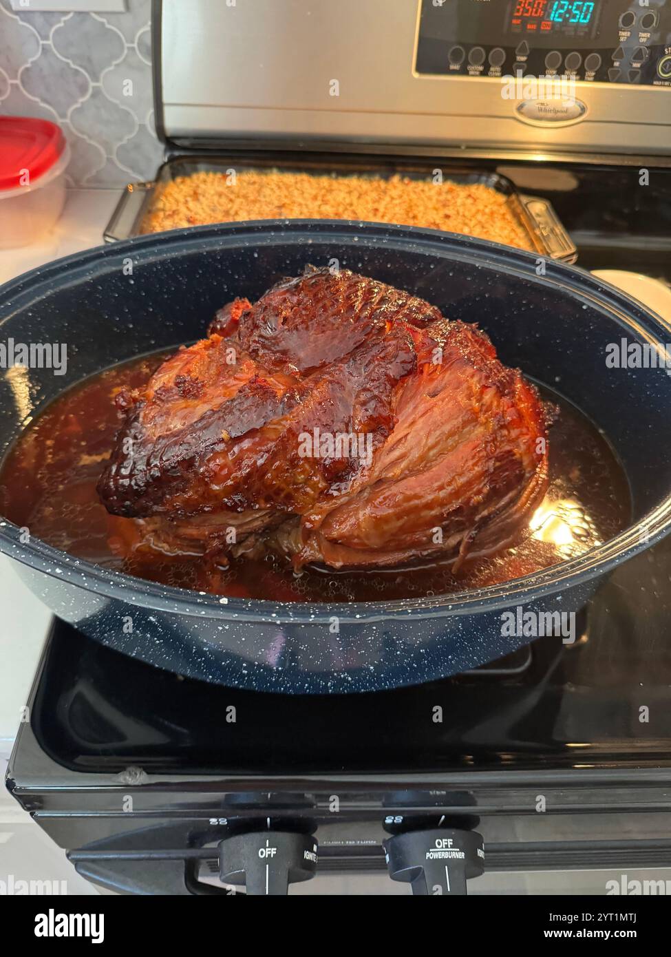 Holiday ham just out of the oven in roaster with glaze juices to be sliced for serving. USA - Smartphone Captured Stock Image