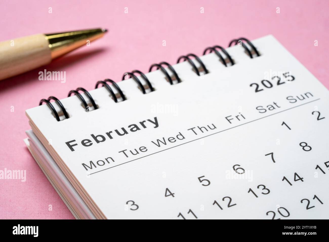 February 2025 - small spiral desktop calendar with a pen, time and ...