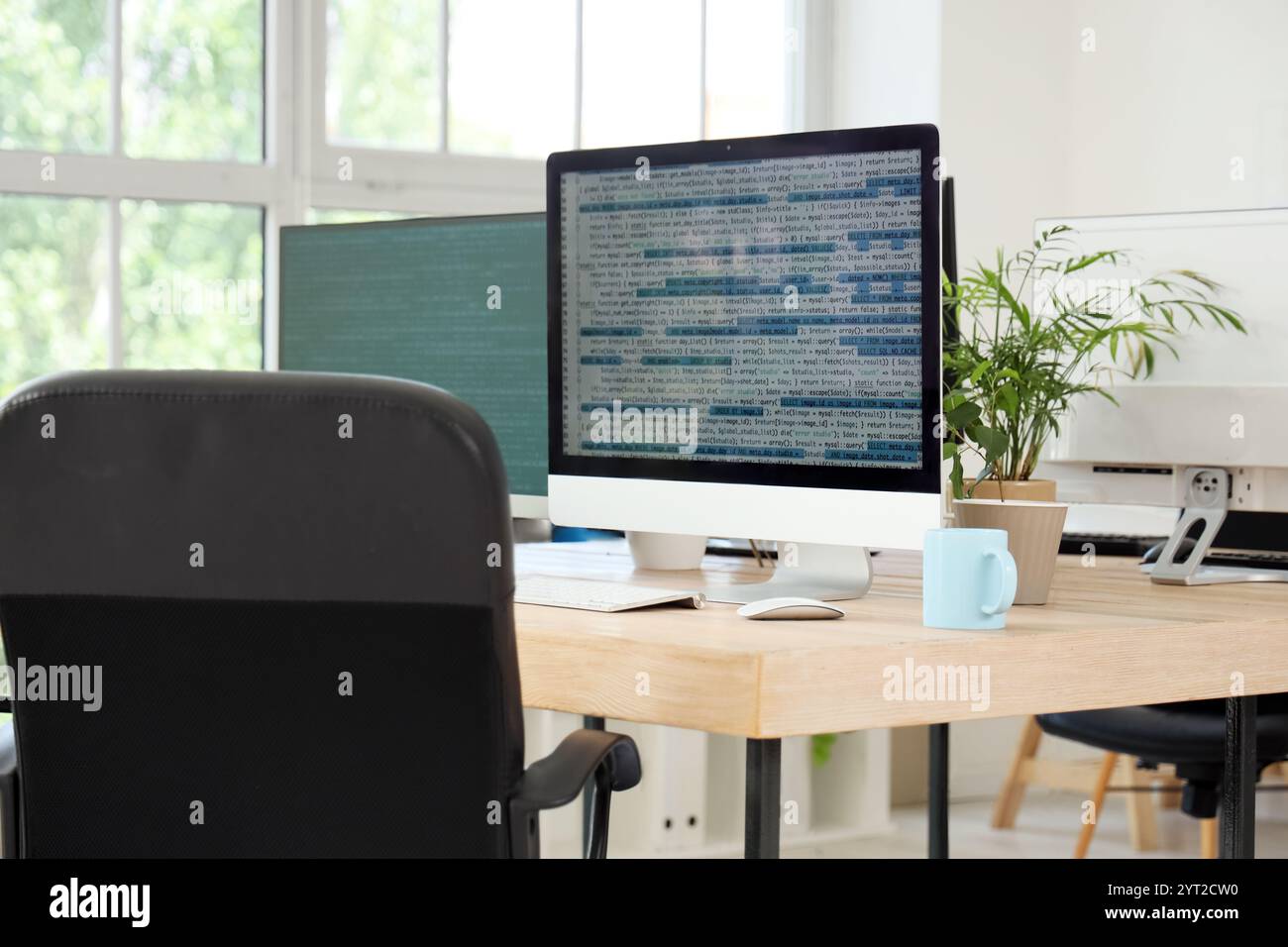 Computer monitors with code on programmer's desk in office Stock Photo ...