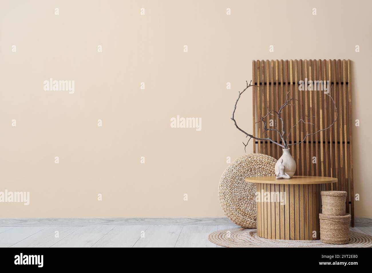 Interior of room with wooden folding screen, table and tree branches in ...