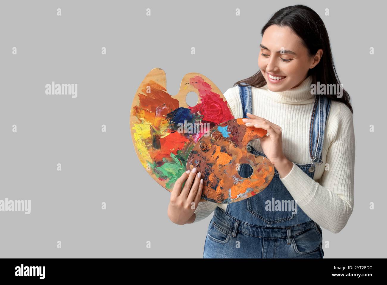 Beautiful female artist with palettes on grey background Stock Photo ...