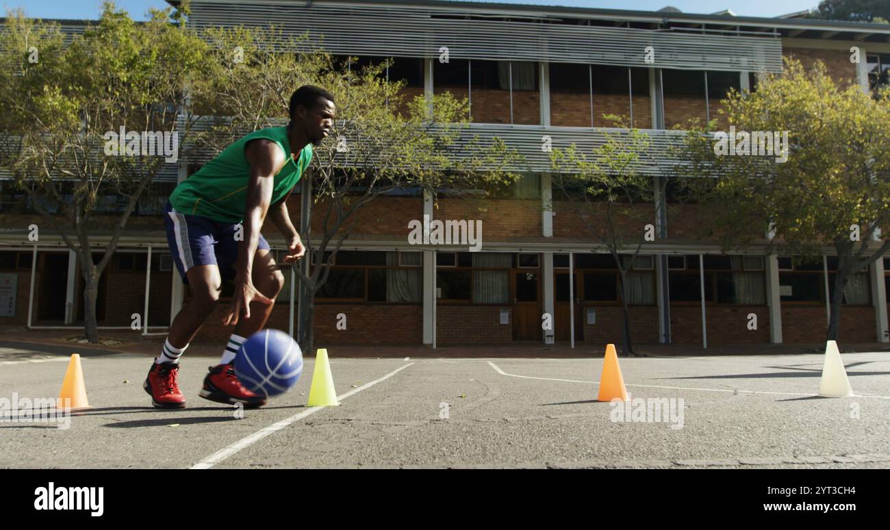 Basketball player practicing dribbling drill in basketball court outdoors Stock Photo