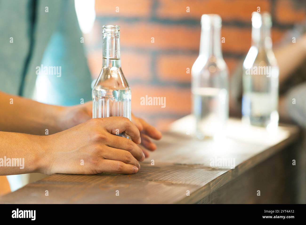 Hand holding a bottle of alcohol Stock Photo - Alamy