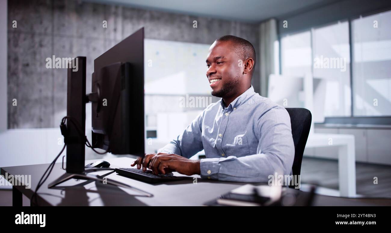 Employee Working On Desktop Computer In Home Office Stock Photo