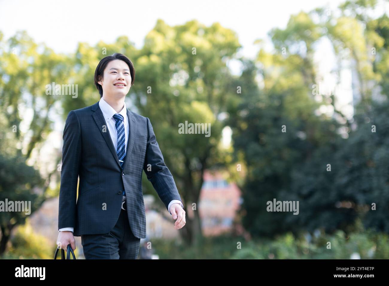 Businessman walking in park Stock Photo - Alamy