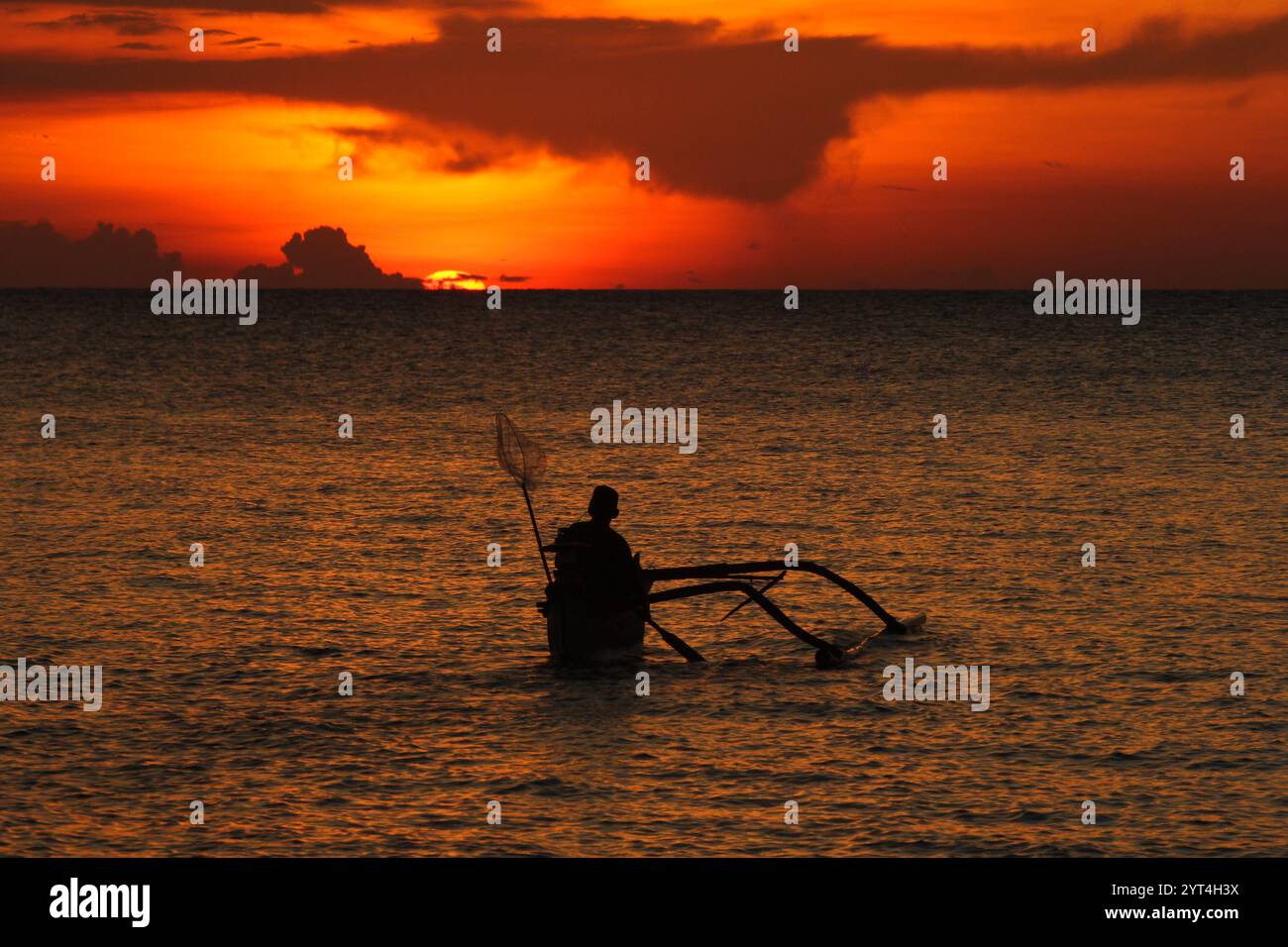 Silhouette of a fisherman on a boat by the sea. Sunset background with ...