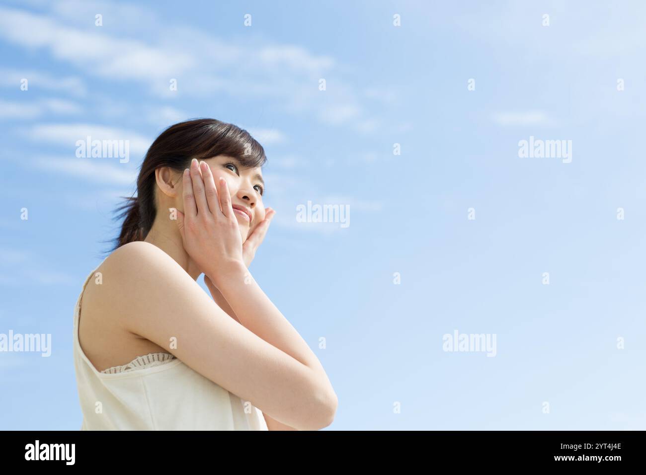 Blue sky and young woman Stock Photo - Alamy