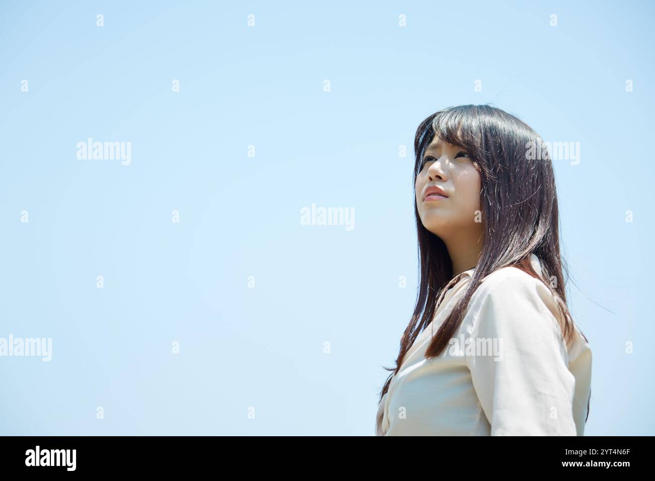 Blue sky and young woman Stock Photo - Alamy