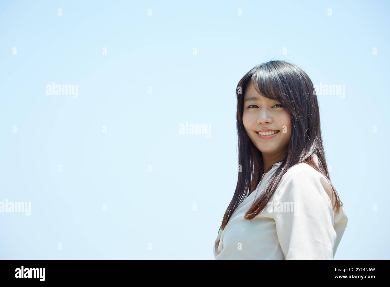 Blue sky and young woman Stock Photo - Alamy