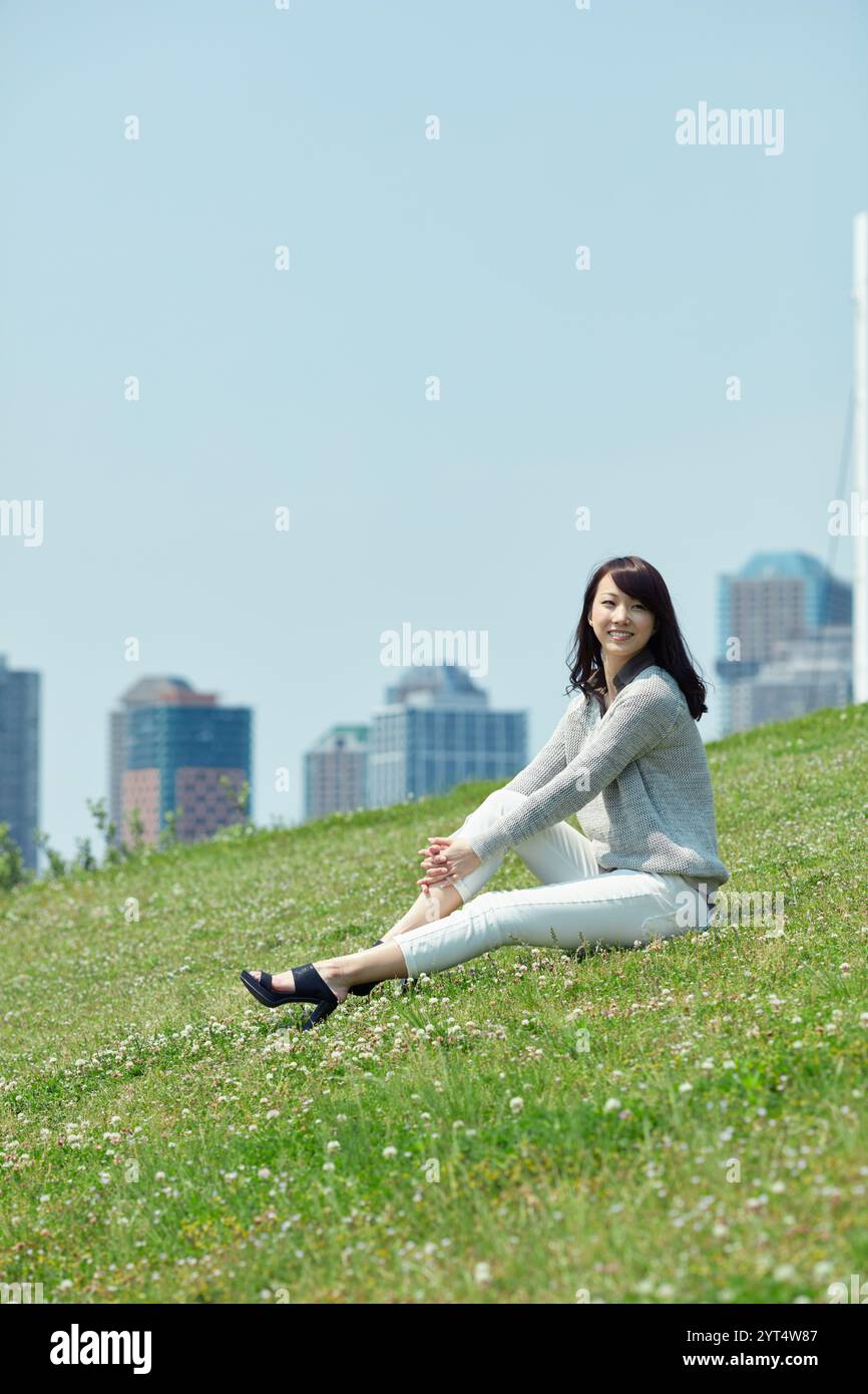 Female sitting on lawn Stock Photo - Alamy