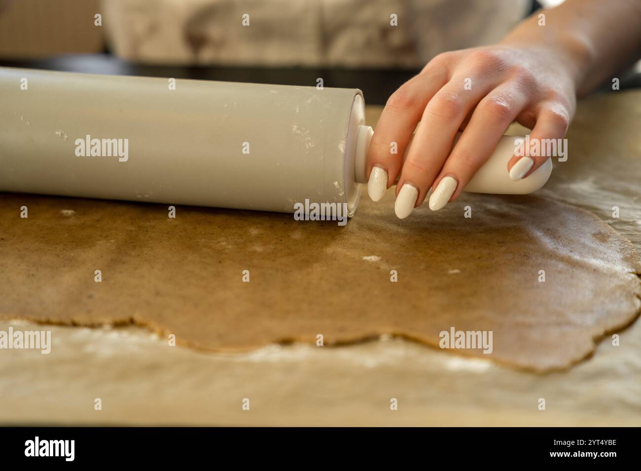 View of Hand rolling dough with rolling pin in kitchen Stock Photo - Alamy