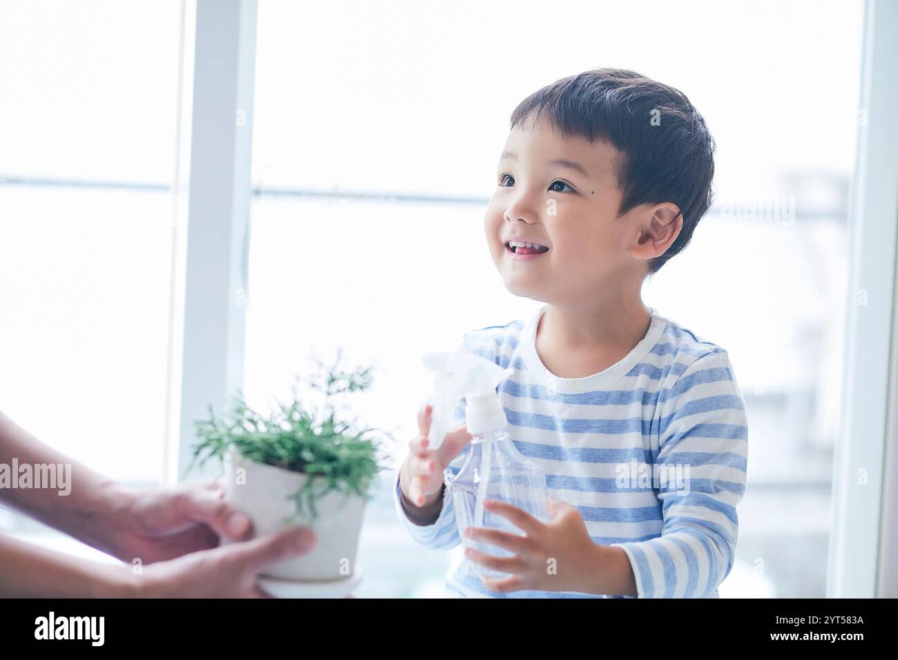 Boy and woman watering plants Stock Photo - Alamy