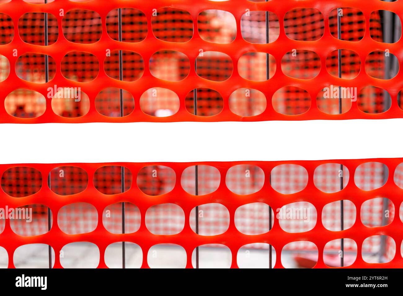Construction site safety barrier with bright orange mesh and an empty white space for text Stock Photo
