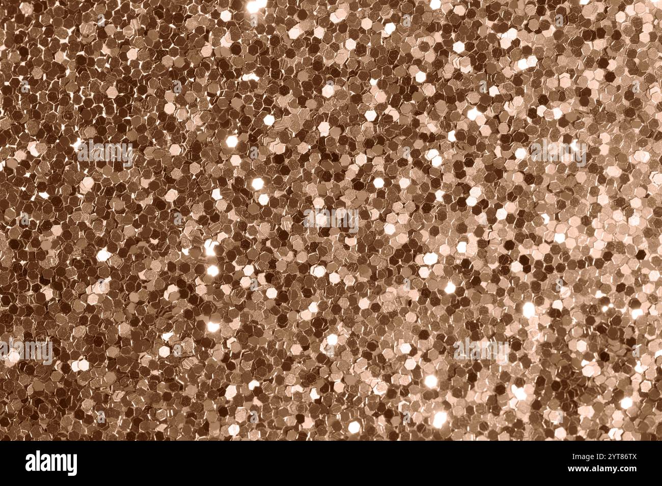 Glittering bronze texture with hexagonal sequins under soft illumination Stock Photo