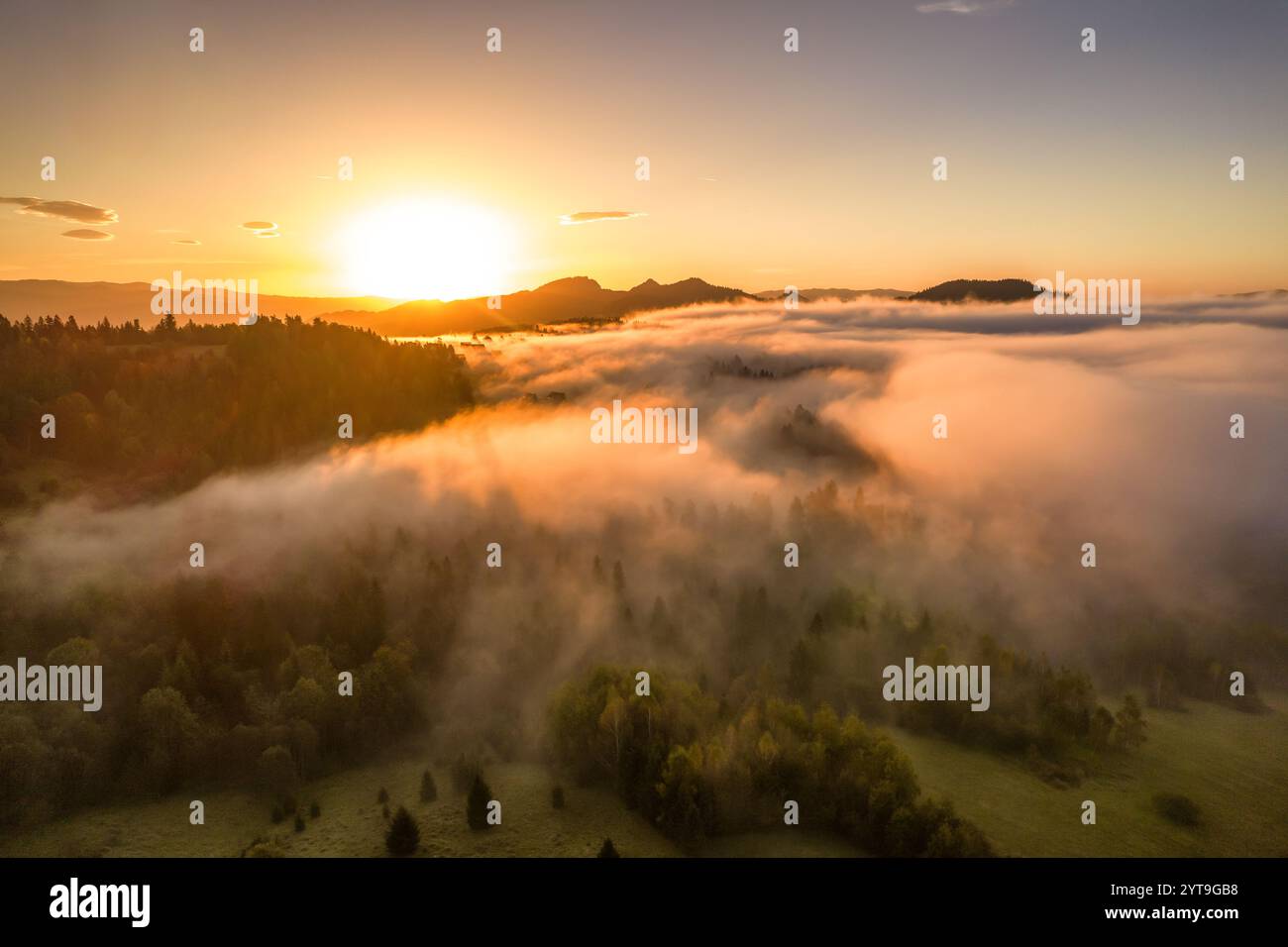 Aerial view of a mountain landscape shrouded in morning fog during ...
