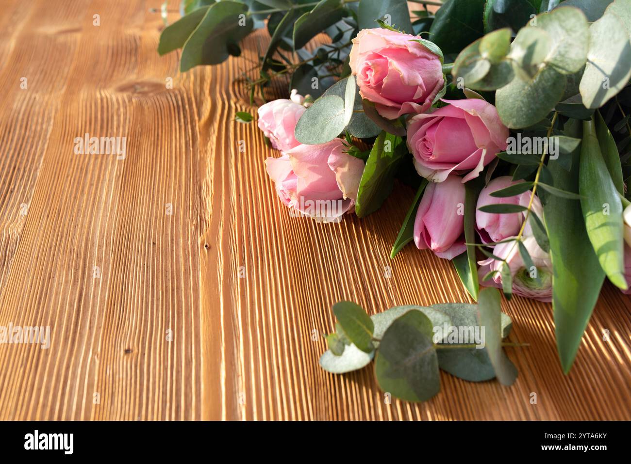 Bouquet of pink roses for mothers day on rustic wood. Background for congratulation with space for text. Stock Photo
