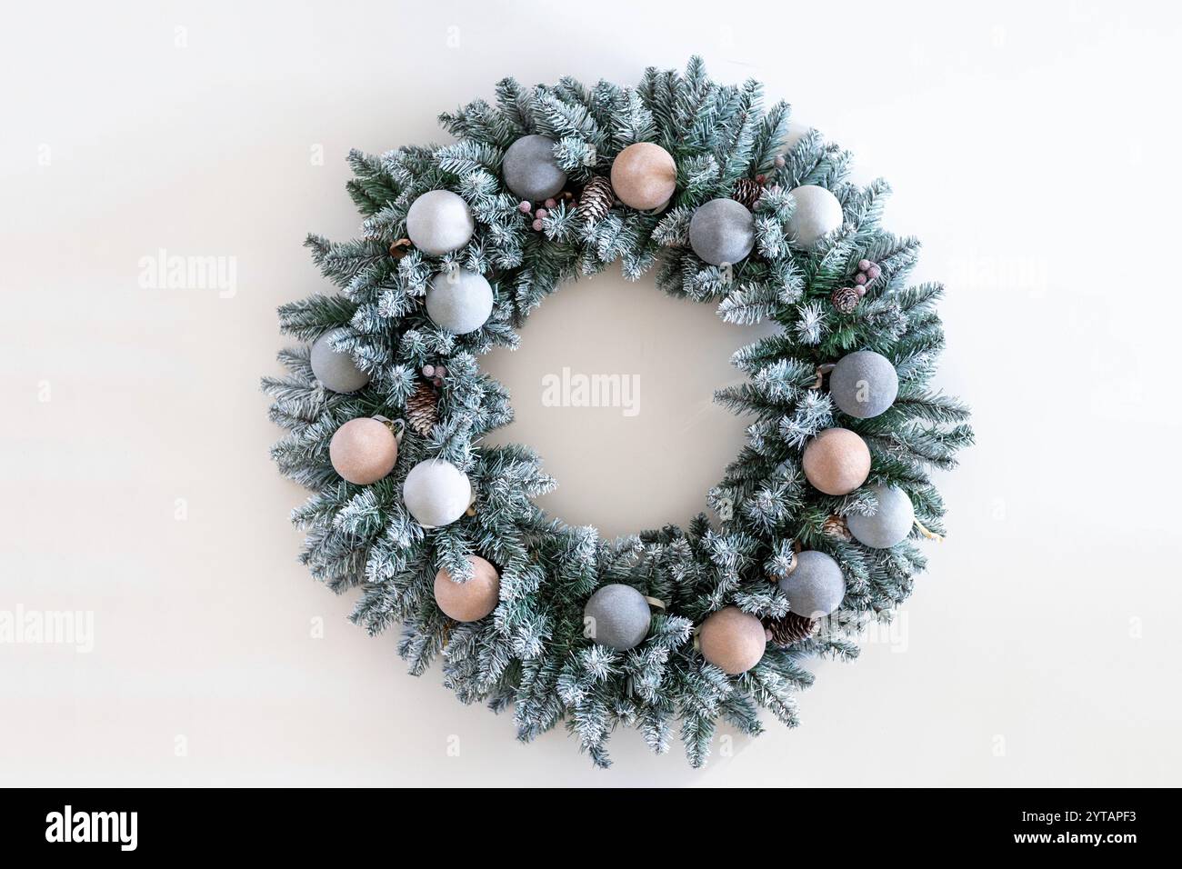 Christmas wreath made of live fir branches and toys on a white ...