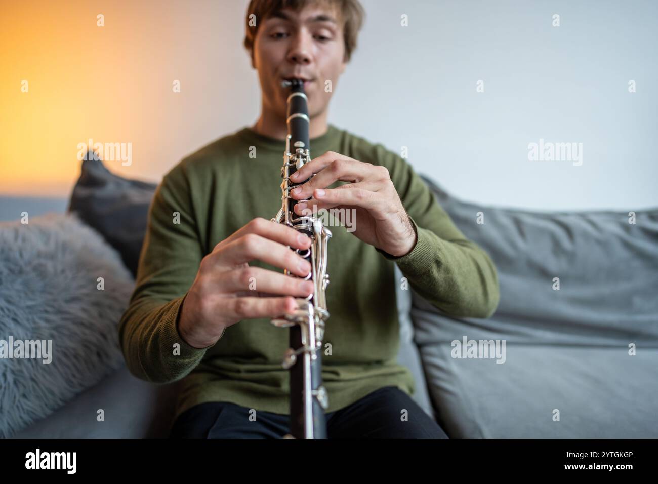 Clarinet player. Clarinetist hands playing flute woodwind music instrument at home. Guy plays oboe Stock Photo