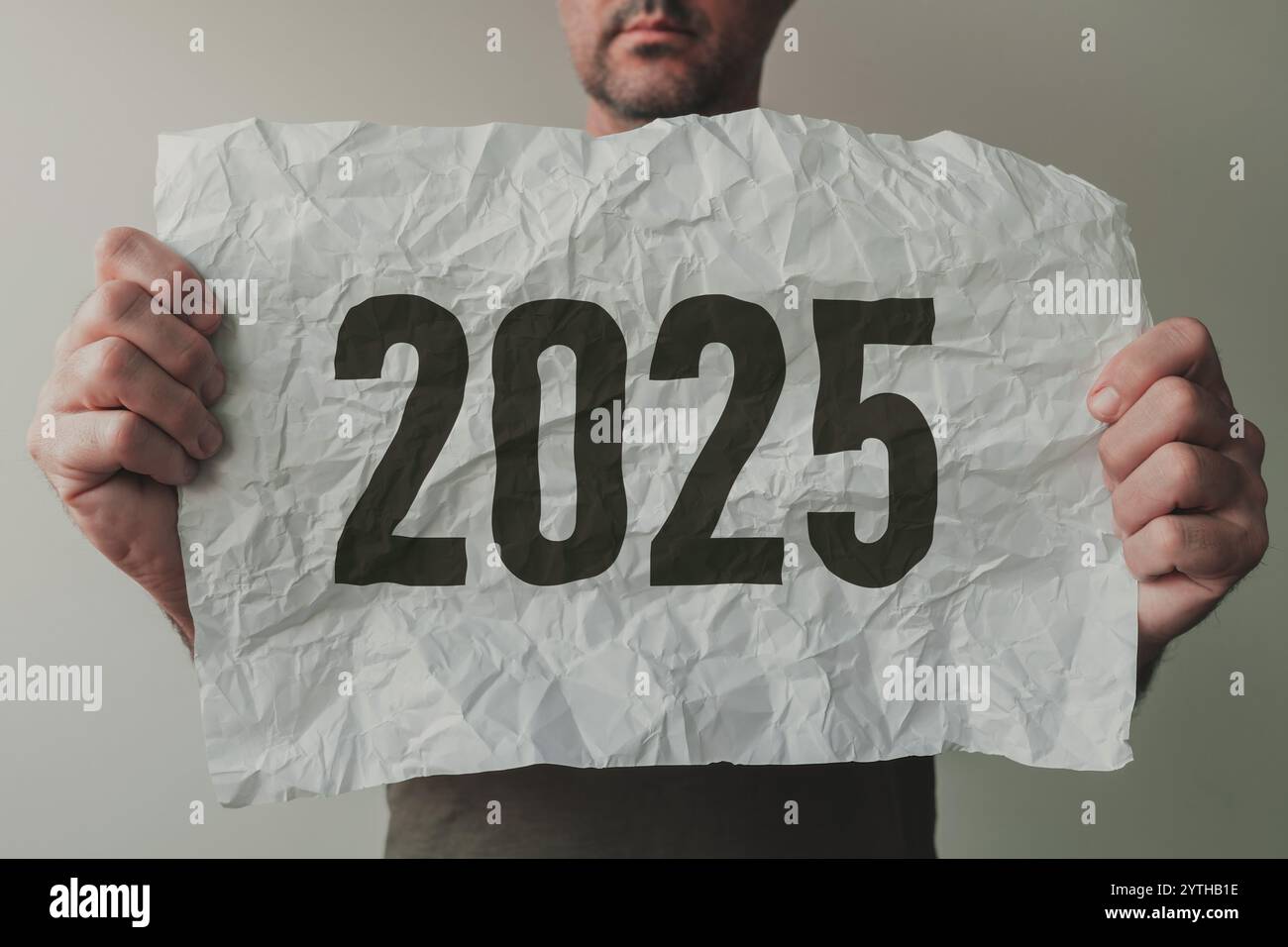 Man holding crumpled white paper with number 2025, selective focus Stock Photo
