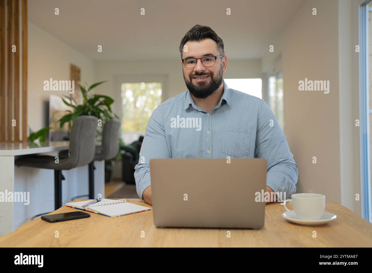 A happy man using a laptop while working at home office. Stock Photo