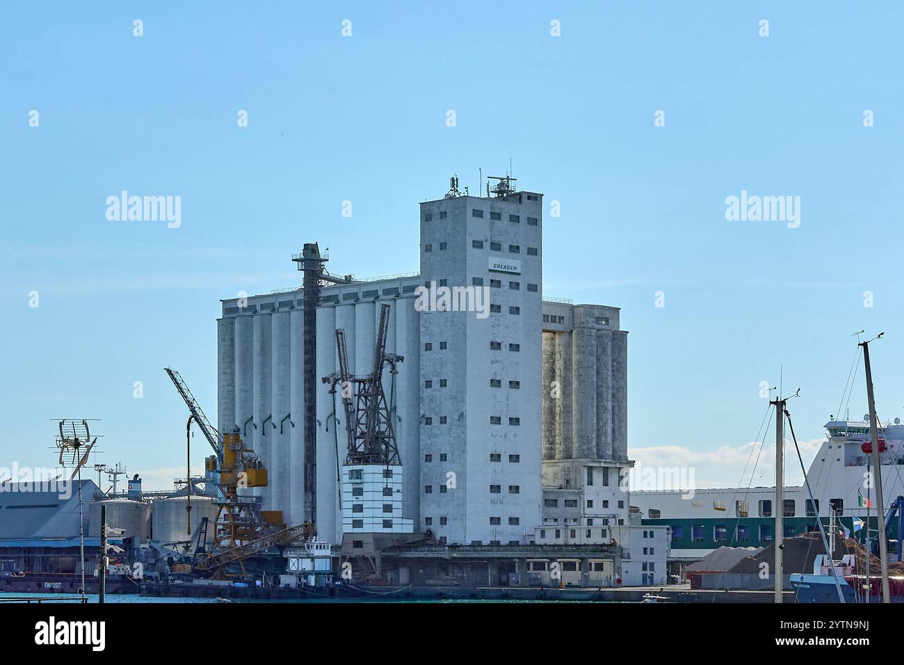 Savona, Italy - December 07, 2024: The Colacem cement factory at Savona port features prominent silos and cranes showcasing industrial infrastructure Stock Photo