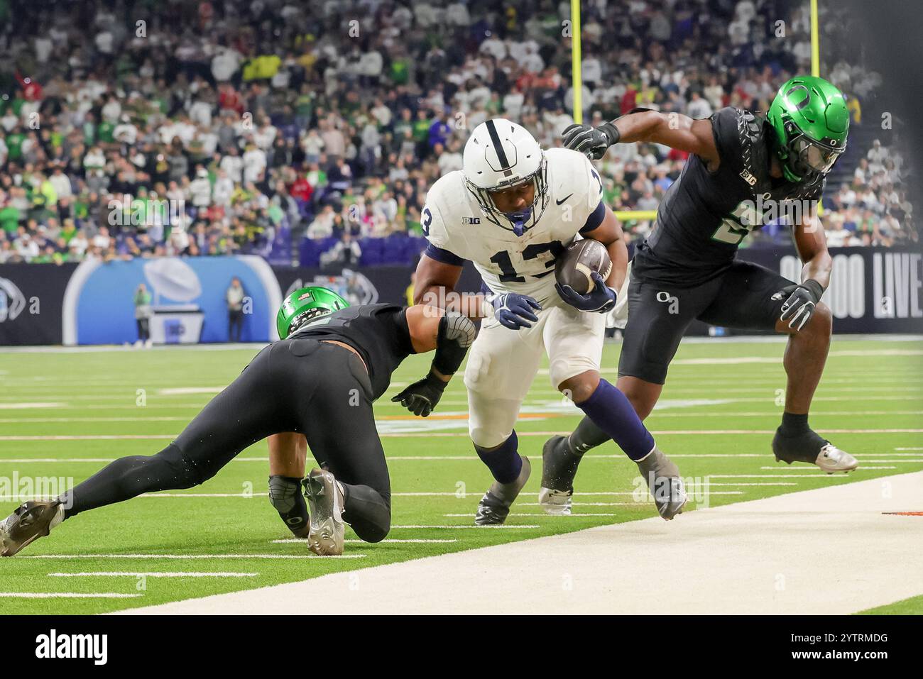 Indianapolis, Indiana, USA. 8th Dec, 2024. Penn State Nittany Lions running back Kaytron Allen (13) is knocked out of bounds by Oregon Ducks linebacker Jeffrey Bassa (2) on a run in the game between the Penn State Nittany Lions and the Oregon Ducks at Lucas Oil Stadium, Indianapolis, Indiana. (Credit Image: © Scott Stuart/ZUMA Press Wire) EDITORIAL USAGE ONLY! Not for Commercial USAGE! Credit: ZUMA Press, Inc./Alamy Live News Stock Photo