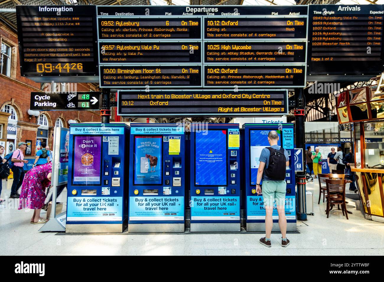 Man buying train ticket at ticket machines on the concourse of Marylebone train station, London, England Stock Photo