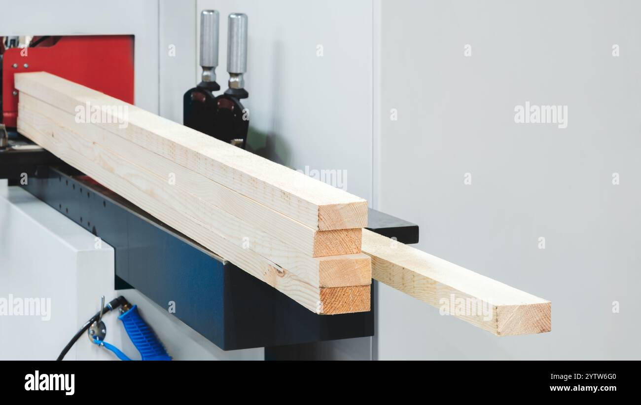 A piece of wood is being cut by a machine. The wood is in the shape of ...
