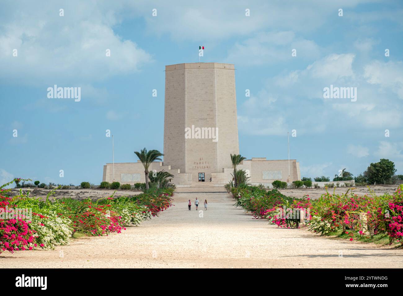 The Italian War Memorial at El Alamein honors the Italian soldiers of World War II, featuring a grand tower, symmetrical gardens, and vibrant desert b Stock Photo