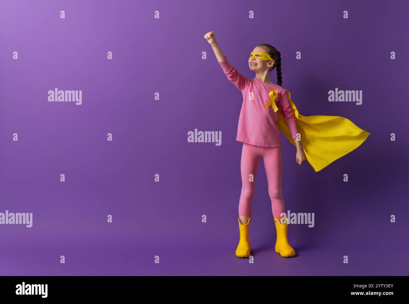 World Childhood cancer Day. Girl in superhero costume with golden ...
