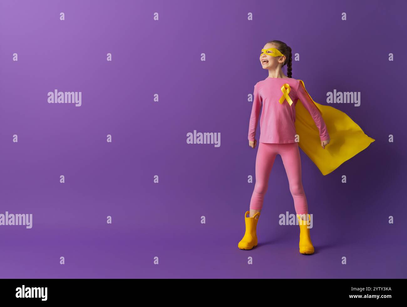 World Childhood cancer Day. Girl in superhero costume with golden ...