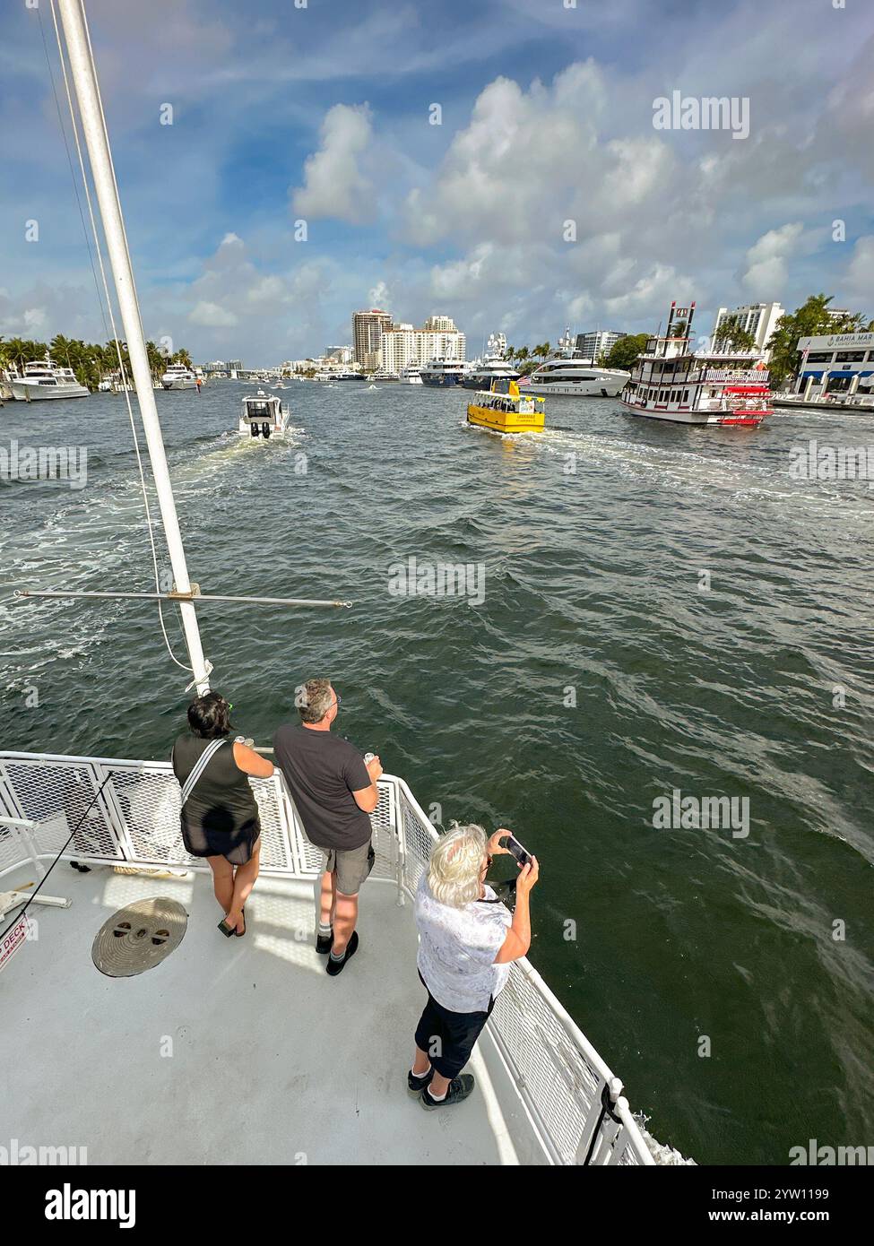 Fort Lauderdale, Florida, USA - 2 December 2024: People standing on the front deck of a tourist sightseeing boat as it sails up the city's waterway - Smartphone Captured Stock Image
