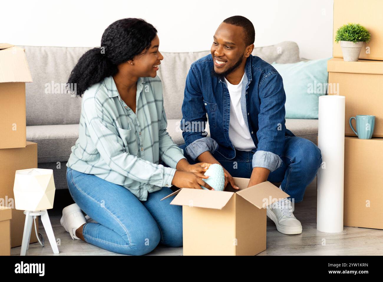 Happy young african american couple moving to new apartment, packing ...