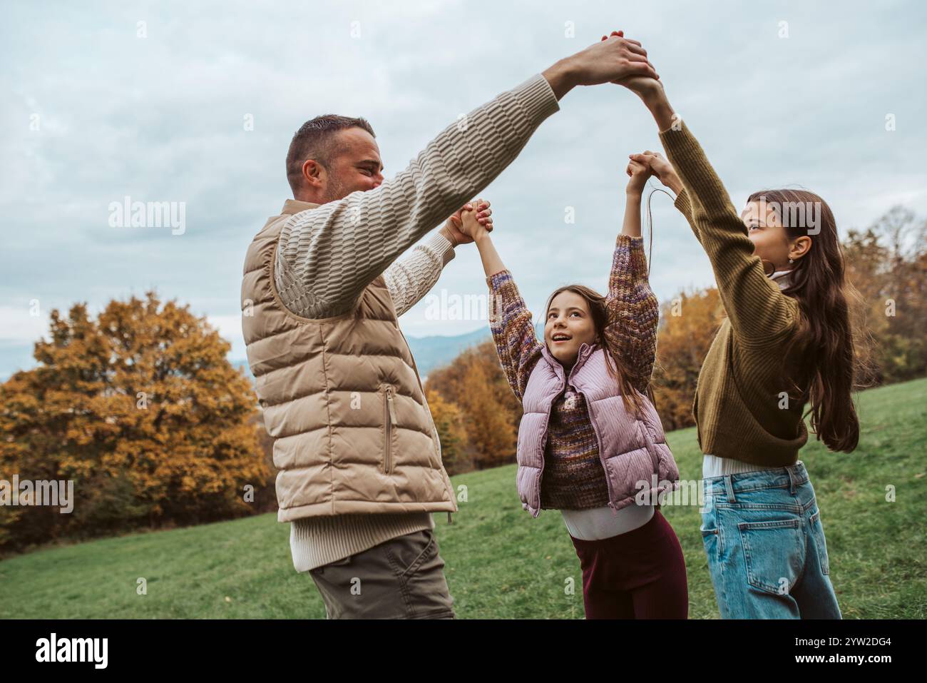 Father dancing with daughters, holding hands Stock Photo - Alamy