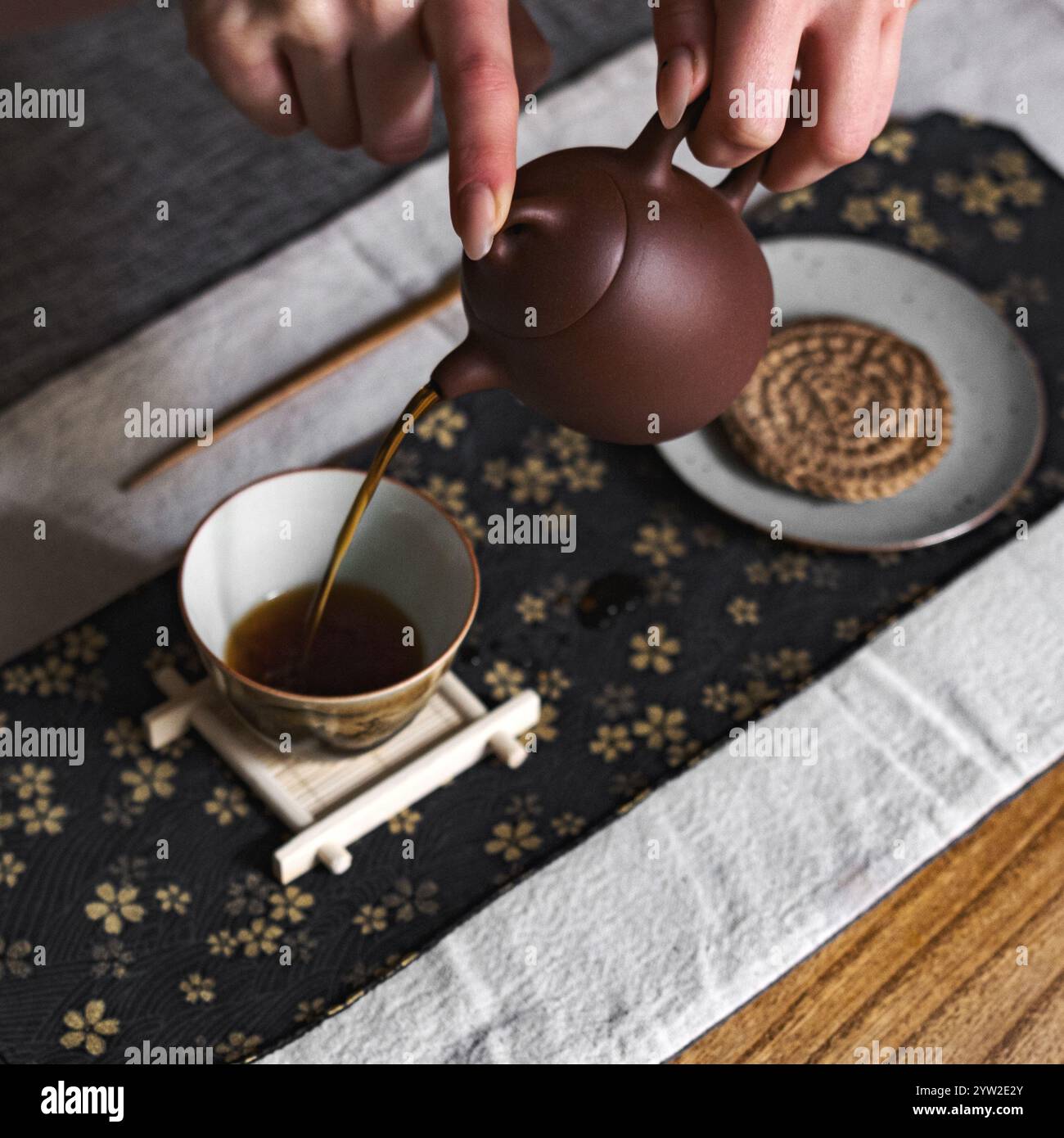 A serene moment captures tea pouring from a teapot, showcasing ...