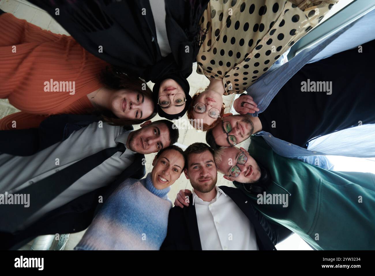 A diverse group of business professionals standing together in a ...